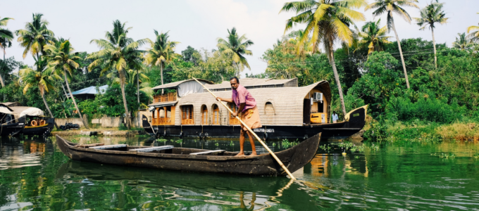 man rowing boat in kerala backwaters